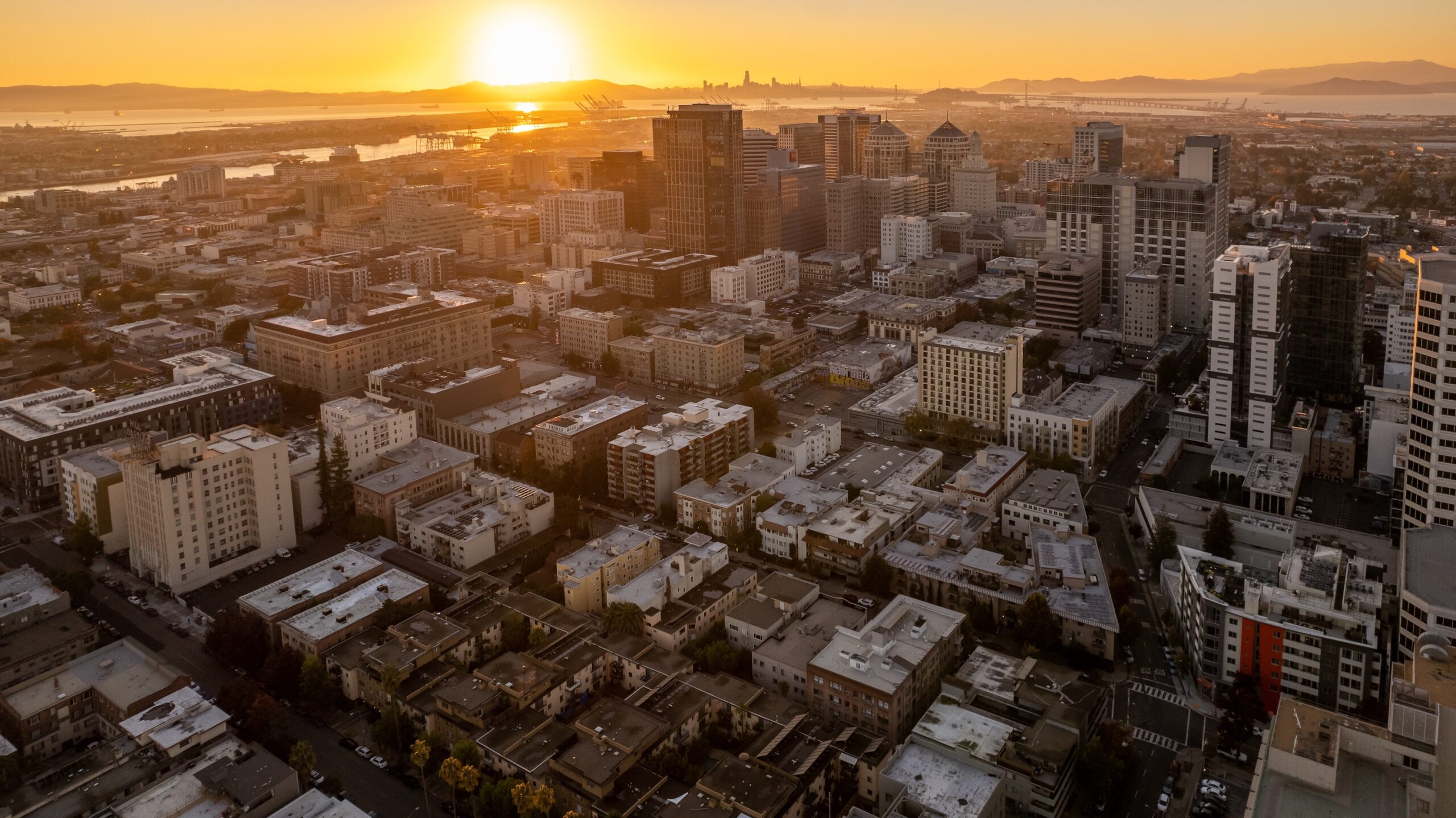 An aerial view of the city of Oakland as the sun sets. 